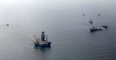 The Development Driller III oil drilling platform is surrounded by support vessels as it is used to drill a relief well at the site of the Deepwater Horizon oil spill in the Gulf of Mexico off the coast of Louisiana Wednesday, May 12, 2010. AP Photo / Charlie Riedel