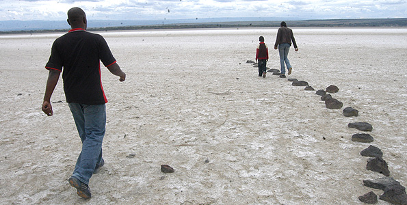 In days gone by, these Kenyans would have swam in the waters of Lake Elementaita, but they now they stroll across a portion of the lake which has dried up due to drought in recent months. This has led to the destruction of catchment areas and climate change. Photo: JOSEPH KIHERI 