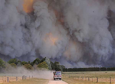 Bushfire dwarfs a fire-truck at Labertouche, near Pakenham, east of Melbourne. Picture: Alex Coppel 