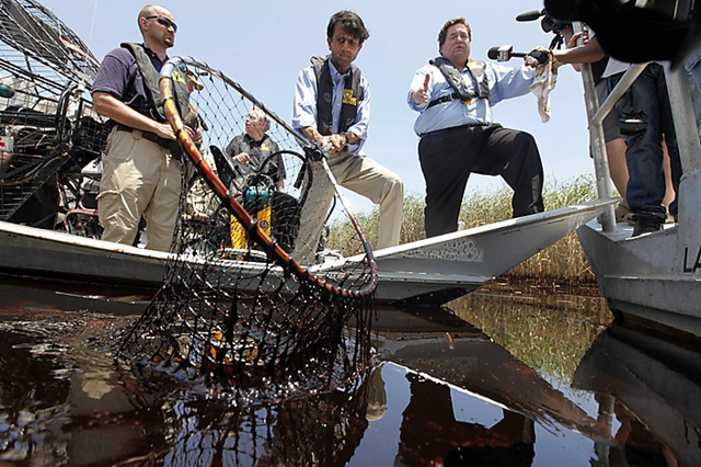 Louisiana Gov. Bobby Jindal (R), center, and Plaquemines Parish President Billy Nungesser, right, tour the oil-impacted marsh of Pass-a-Loutre, Louisiana, 19 May 2010. Gerald Herbert / AP