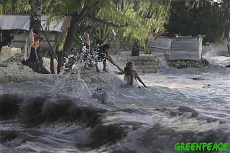 A family living next to the sea in the village of Betio, on the South Pacific island of Kiribati, pull themselves from the high waves of the 2005 'king tide.' Greenpeace