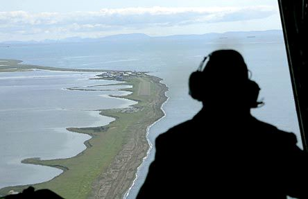 Aviation Maintenance Tech 2 John Ferrari looks out of the back of a Coast Guard C-130 as he surveys the coast near the village of Kivalina Alaska during a surveillance flight to the Arctic in 2008. Scientists say climate change is eroding the coast at a faster rate. AP File Photo / Al Grillo