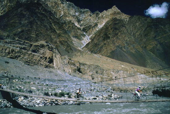 Biking Over The Hunza River, Gilgit, Pakistan. Our group takes off across one of the many rickety bridges that span the Hunza River, connecting the new road (opened in 1974) with the ancient track that had been used for hundreds of years. Marjorieandpaul / travelpod.com