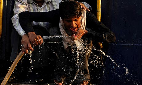 A train passenger quenches his thirst in Allahabad as temperatures in the Indian city soared above 113 degrees Fahrenheit. Photograph: Diptendu Dutta / AFP / Getty Images