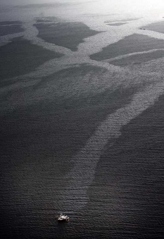 A shrimp trawler drags oil containment booms in Barataria Bay, leaving a streak in the oil in the waters as crude makes landfall on Louisiana's barrier island beaches and inundates Barataria Bay, even as oil continues to spew from the Deepwater Horizon spill into the Gulf of Mexico, Wednesday, June 2, 2010. PHOTO BY TED JACKSON / THE TIMES-PICAYUNE