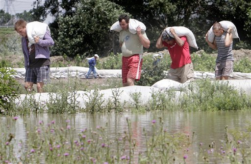 Men carry sand bags to reinforce a dyke in Sendreni, eastern Romania, Thursday, July 1, 2010. Eastern Romania is affected by flooding caused by high levels of the Danube and Siret river that left more than 20 people dead and thousands displaced. Vadim Ghirda via kansascity.com