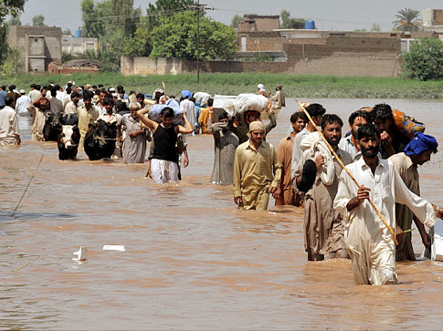 Evacuating residents carry their belongings through floodwaters in Pakistan, 31 July 2010. Majeed / Getty