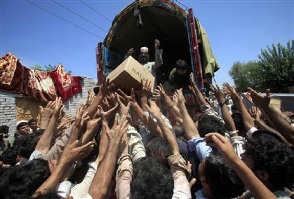 Flood victims raise their hands to collect relief supplies from the Army in Nowshera, located in Pakistan's northwest Khyber-Pakhtunkhwa Province, August 4, 2010. REUTERS / Faisal Mahmood