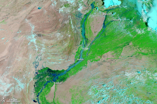In this MODIS image from 11 August 2010, a combination of infrared and visible light is used to increase the contrast between water and land. Water appears in varying shades of blue, and clouds appear in varying shades of blue-green. Vegetation is green, and bare ground is pinkish brown. The Indus, Jhelum, and Chenab Rivers are swollen, and the Indus River has pushed over its banks even before it meets the tributaries flowing from the east. NASA images courtesy the MODIS Rapid Response Team at NASA GSFC. 
