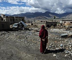 Tibetan Buddhist monk Thupten Dhargyes offers prayers alongside the path of flash floods in the village of Chuglamsar, one of the worst-hit areas during the August 6 floods, on the outskirts of Leh on August 16, 2010. Some 189 people were reported dead and more than 400 are still missing following overnight flash floods which hit the remote Himalayan town on 6 August 2010. AFP