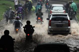 Motorbikes splash through deep puddles of water after heavy rains lashed the Semanggi area of Jakarta on Wednesday, 18 August 2010.&ensp;JG Photo / Safir Makki 