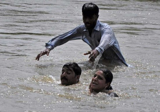 People displaced from flooded areas wade through high waters towards higher grounds in Basera, near Muzaffargarh, Punjab province, Pakistan on 02 September 2010. The United Nations has warned that up to 3.5 million children were at risk from water-borne diseases in flood-hit Pakistan and said it was preparing to deal with thousands of potential cholera cases. EPA / SHABBIR HUSSEIN IMAM