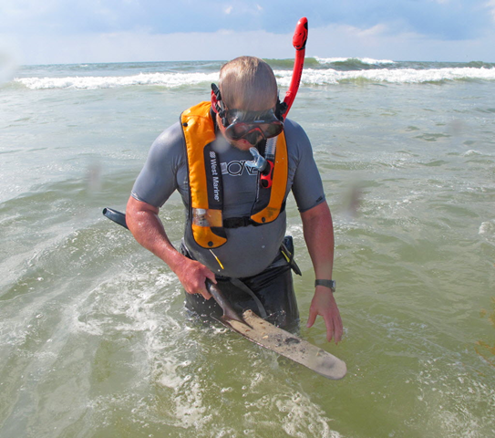 Todd Farrar, a BP contractor with the Shoreline Cleanup Assessment Team working its way along the Gulf Coast, examines a layer of oil buried a few inches below the seafloor at the Bon Secour National Wildlife Refuge. He estimated the sample contained about 15 percent oil, with the rest composed of sand and seashells. Press-Register / Ben Raines