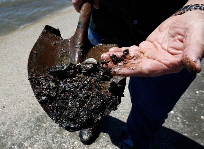 Wisner land field inspector Forrest Travirca, III displays oil-fouled material taken from the area the surf Tuesday, September 14, 2010. The beach may appear devoid of oil, but scratching the surface reveals oil just below the top layer of sand. John McCusker, The Times-Picayune