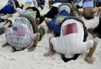 Activists put their heads in the sand to symbolize that countries are not doing enough to fight climate change a beach in Cancun. Reuters