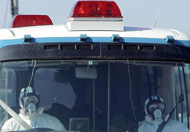 Police wearing protective clothing and respirators head towards the Fukushima Daiichi Nuclear Plant in trucks in Minamisouma City, Fukushima Prefecture March 12, 2011. Reuters / Yomiuri