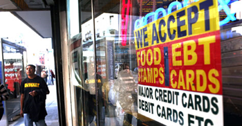 Storefront sign: 'We accept Food Stamps / EBT cards'. A record number of Americans is receiving food stamps. Spencer Platt / Getty Images