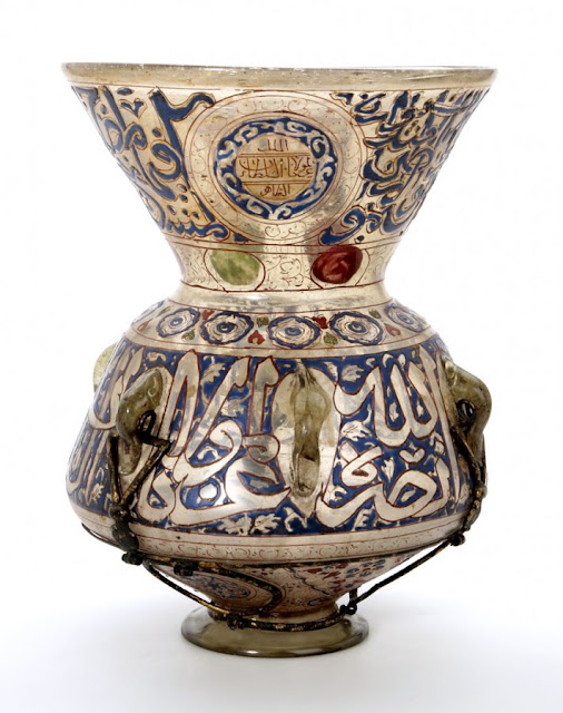 The rim of this lamp bears an inscription from the surah al-Nur (Light), verse 35: "God is the Light of the heavens and the earth. The parable of His Light is as if there were a Niche and within it a Lamp: the Lamp enclosed in Glass." Syria or Egypt. 15th century. 33 x 25 cm. Courtesy of the Nasser D Khalili Collection of Islamic Art.
