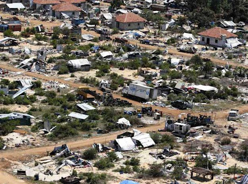 An abandoned UN World Food Program vehicle lays amidst the devastation, seen in this aerial photo showing part of the former conflict zone on the north east coast on the Jaffna peninsula of Sri Lanka, Saturday, May 23, 2009.  Many thousands of Tamil people were displaced over the final months of fighting, leaving some areas largely deserted, with displaced people being housed in tented camps. (AP Photo/Kirsty Wigglesworth)