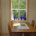 The breakfast nook is situated near the full kitchen.