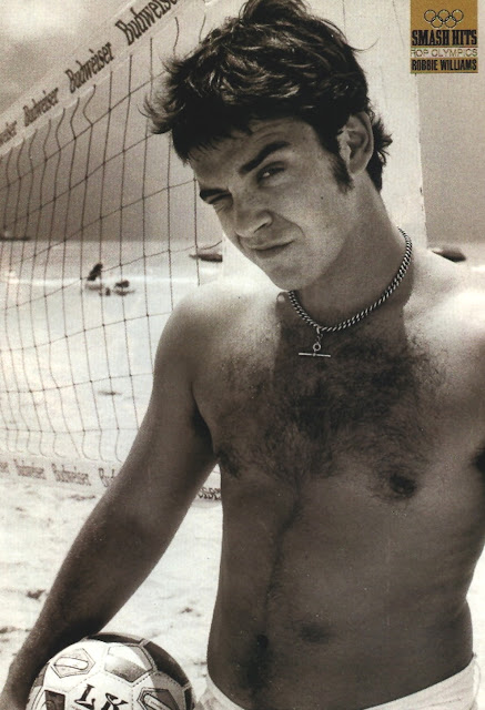 young robbie williams shirtless at the beach showing off his hairy chest