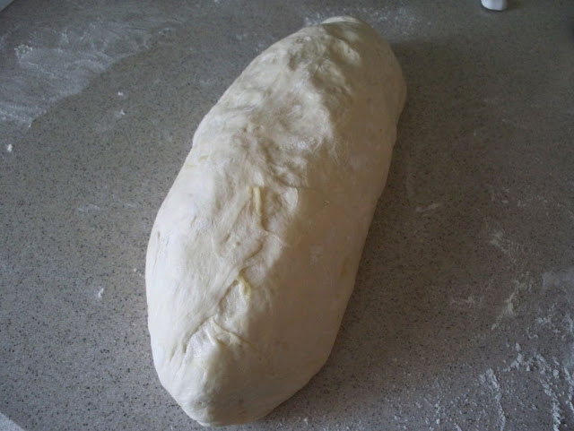 Continue rolling toward you, shaping the loaf into a log shape.