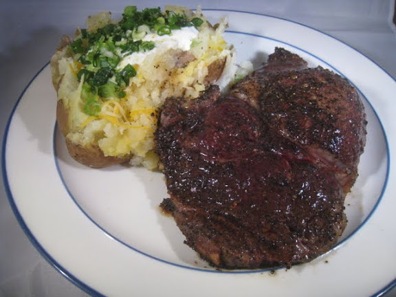 Coffee Crusted Rib eye alongside a Baked Potato