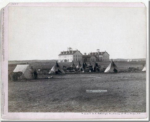 Title: U.S. School for Indians at Pine Ridge, S.D.
Small Oglala tipi camp in front of large government school buildings in open field. 1891.
Repository: Library of Congress Prints and Photographs Division Washington, D.C. 20540