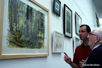 Jock Nichol showing his painting to interested onlooker.