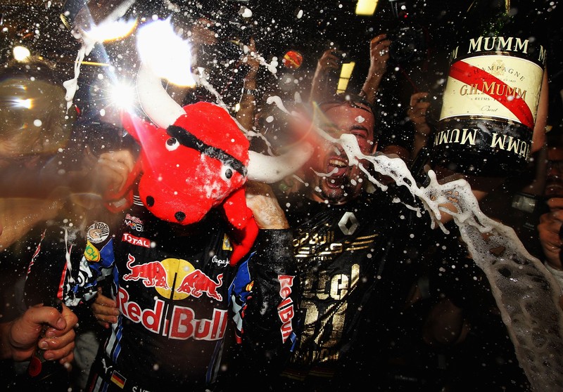 Себастьян Феттель наслаждается победой вместе со своими механиками на Гран-при Абу-Даби 2010