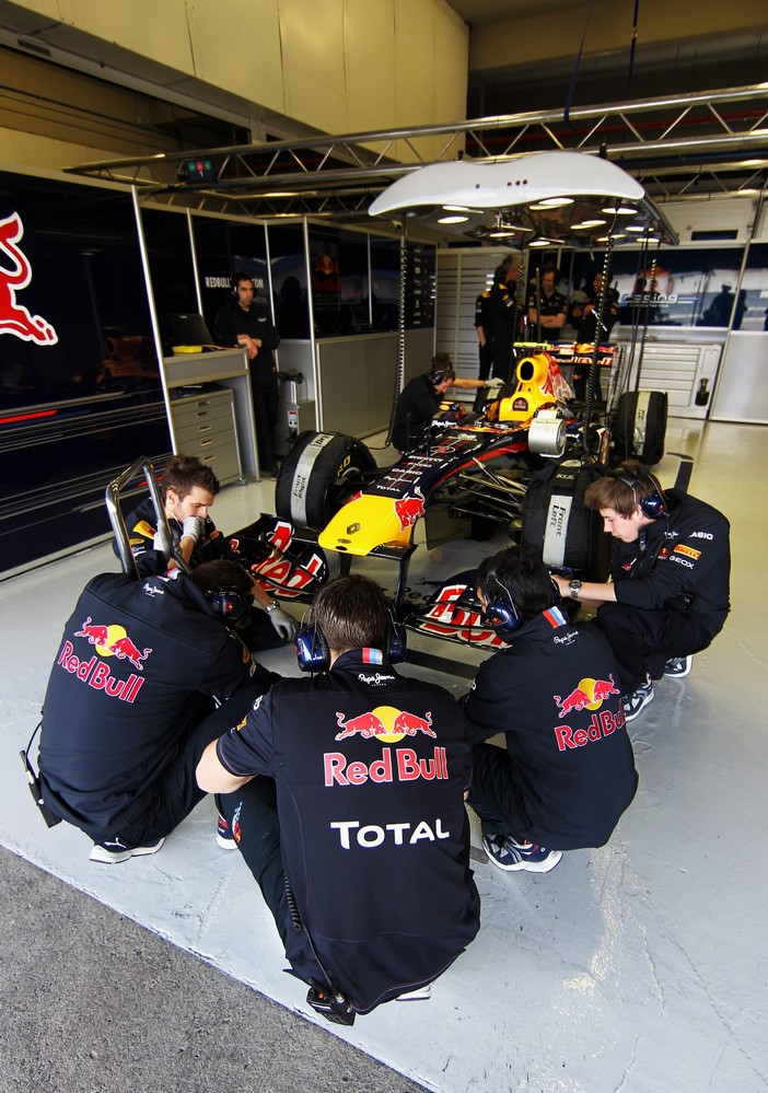 механики Red Bull в кружке на корточках на тестах в Хересе 2011