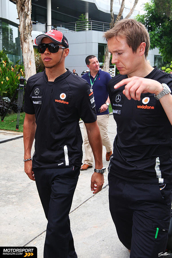 Льюис Хэмилтон идет по паддоку вместе с механиком на Гран-при Малайзии 2011