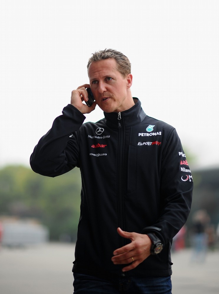 Михаэль Шумахер разговаривает по телефону в паддоке Шанхая на Гран-при Китая 2011