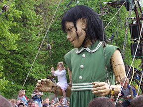 The girl kneeling down so kids can swing on her arms