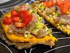 Raw bread with a marinated/dehydrated squash pattie and onions, red bell peppers and radish sprouts. You have to taste to believe the goodness in here.