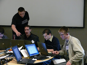 Daniel pointing out something to Darin, while Gary and Ruslan research and investigate