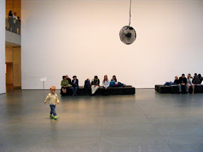 At MoMA (Museum of Modern Art). The fan was a pendulum swinging from a high ceiling on the 2nd floor of the museum. This kid and another one were chasing it.