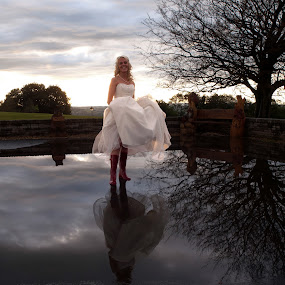 A wet wedding, Bride in Wellington boots. by Tommy  Cochrane - Wedding Bride ( wedding, puddle, wellington, wet, bride, rain, boots, reflection. )
