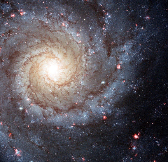 Uma galáxia espiral com vários pontos rosa de formação de estrelas por ondas de choque