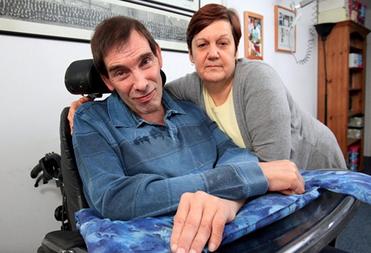 Jane Nicklinson with husband Tony Nicklinson at home in Melksham, Wilts. A father-of-two with "locked in" syndrome says he will go to Swiss clinic Dignitas to die - unless the British Government changes the law on assisted suicide. Civil engineer Tony Nicklinson, 56, lost all movement in his body from the neck down after suffering a sudden catastrophic stroke on a business trip to Greece in 2005. The helpless husband is confined to a wheelchair and can tragically only communicate through moving his head and eyes. Now he says he wants wife Jane, 55, to help him in a "mercy killing" - or the determined dad will fly out to the assisted dying group Dignitas in Switzerland. See swns story SWLOCK , 17 Dec 2010.