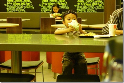a kid eating chicken burger like mine