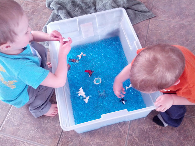 Kids playing with water beads in an arctic animals sensory bin