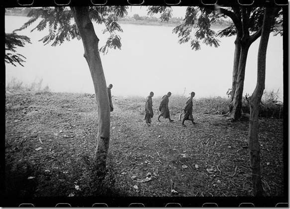 Monks walk along the Mekong River in northern Thailand