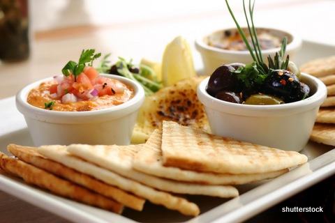 Sumptious platter of flat breads served with red pepper hummus dip, crab dip, olives and grilled haloumi cheese. Shallow DOF.