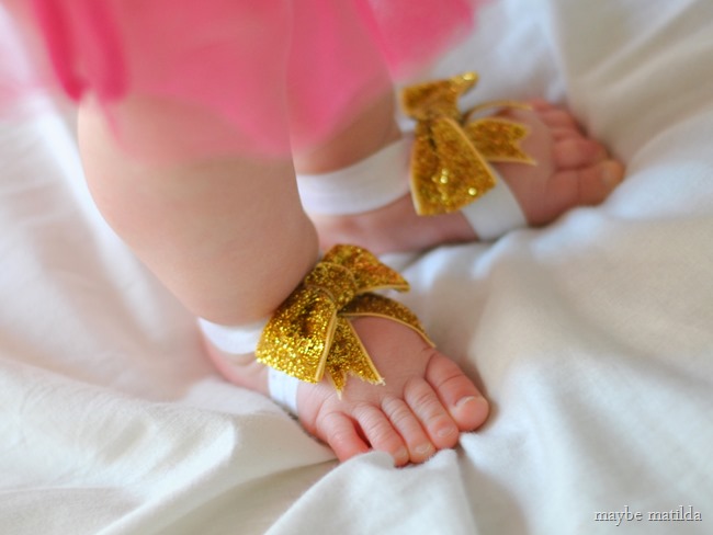 Get the tutorial to make these easy no-sew Glitter Bow Baby Barefoot Sandals!