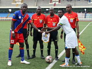 De gauche à droite, le capitaine de l'équipe de la RDC et celui du Gabon échangeant de fanions ce 30/04/2011 au stade des martyrs de Kinshasa, devant les quatre arbitres de la rencontre, lors des éliminatoires des jeux africains Maputo 2011 (RDC 1 - Gabon 0).