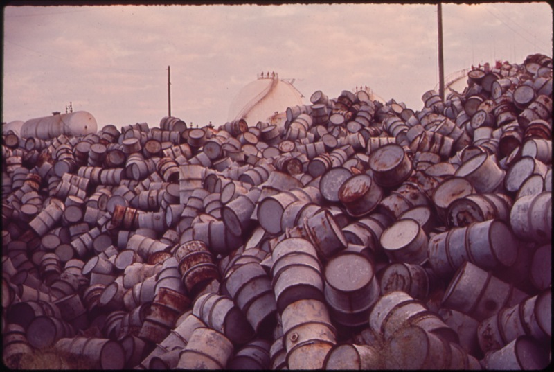 CC Photo Google Image Search Source is upload wikimedia org  Subject is A MOUNTAIN OF DAMAGED OIL DRUMS NEAR THE EXXON REFINERY NARA 546000