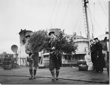 Two sailors carrying the Christm tree and holly