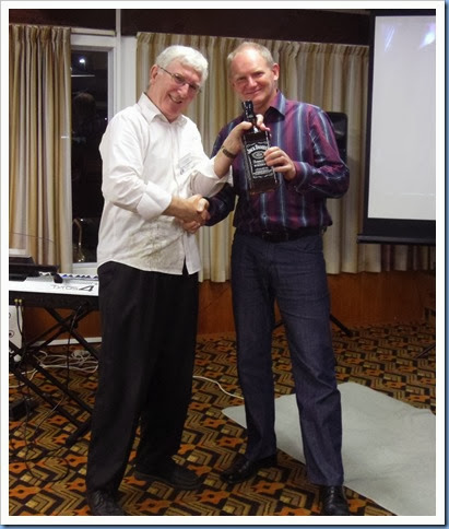 Club President, Gordon Sutherland, presenting our guest artist, Dave Hallam, with a 1.75 litre bottle of Jack Daniels, Kentucky whiskey and well earned too! Photo courtesy of Dennis Lyons.