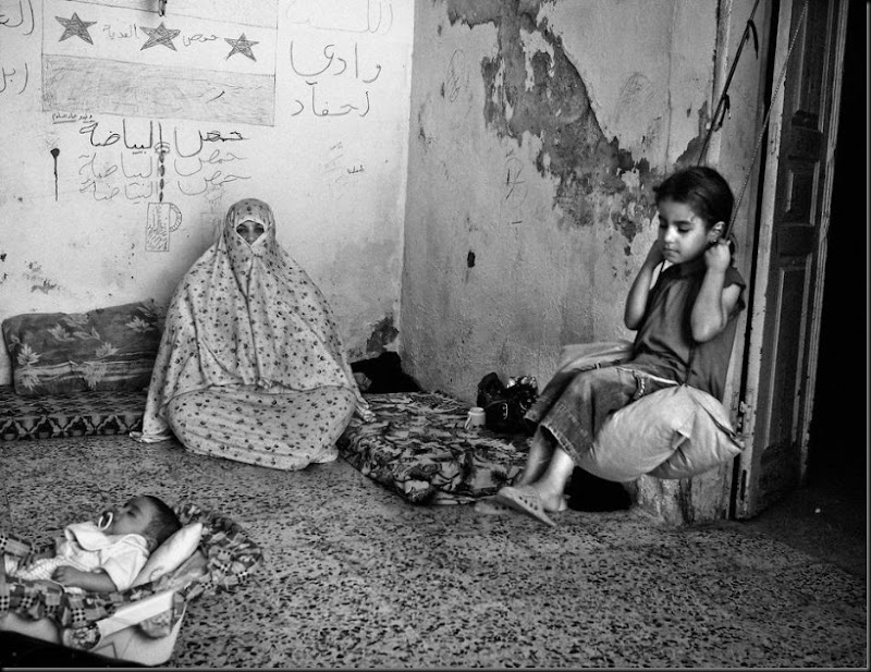9-year-old Rania (right), sits on a swing inside her extended family's home in East Amman, an area where many Syrian refugees have rented apartments. Her father and all the men in the family are still in Syria. (Moises Saman/Magnum Photos for Save the Children)